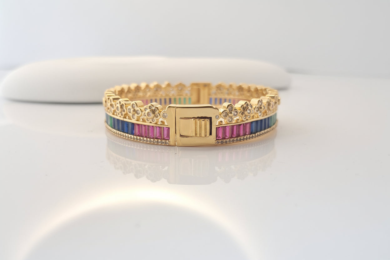 Gold bracelet with colorful stones on a white background