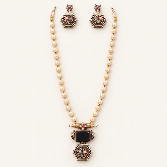 A gold-toned jewelry set featuring a pearl-beaded necklace with a decorative pendant and matching drop earrings, displayed on a clean off-white background.