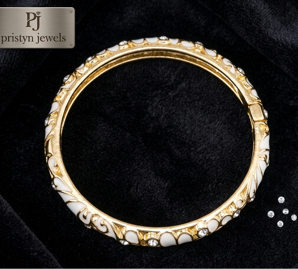 A gold-plated hinged bangle bracelet decorated with white mother-of-pearl inlay and small clear rhinestones, displayed on a black velvet background with a 'pristyn jewels' brand logo in the top-left corner.