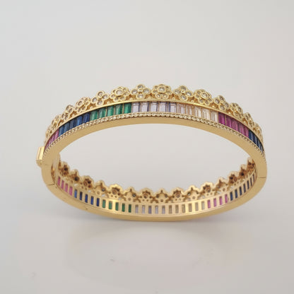 Gold bracelet with colorful stones on a white background