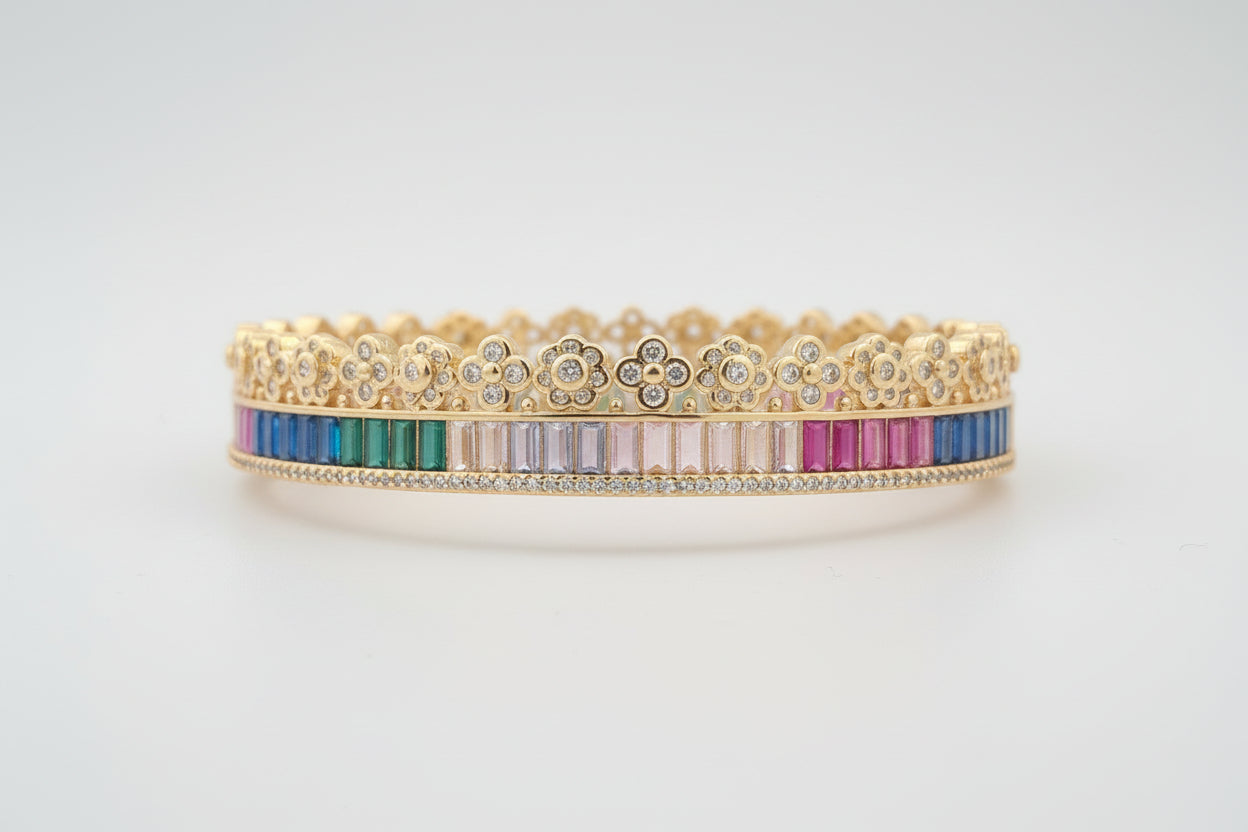Gold bracelet with multicolored stones on a white background