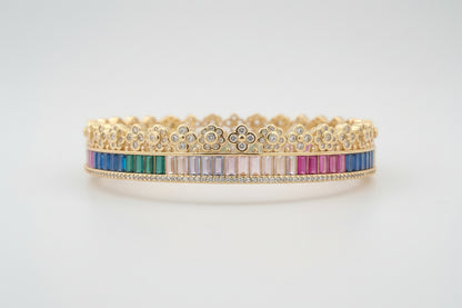 Gold bracelet with multicolored stones on a white background