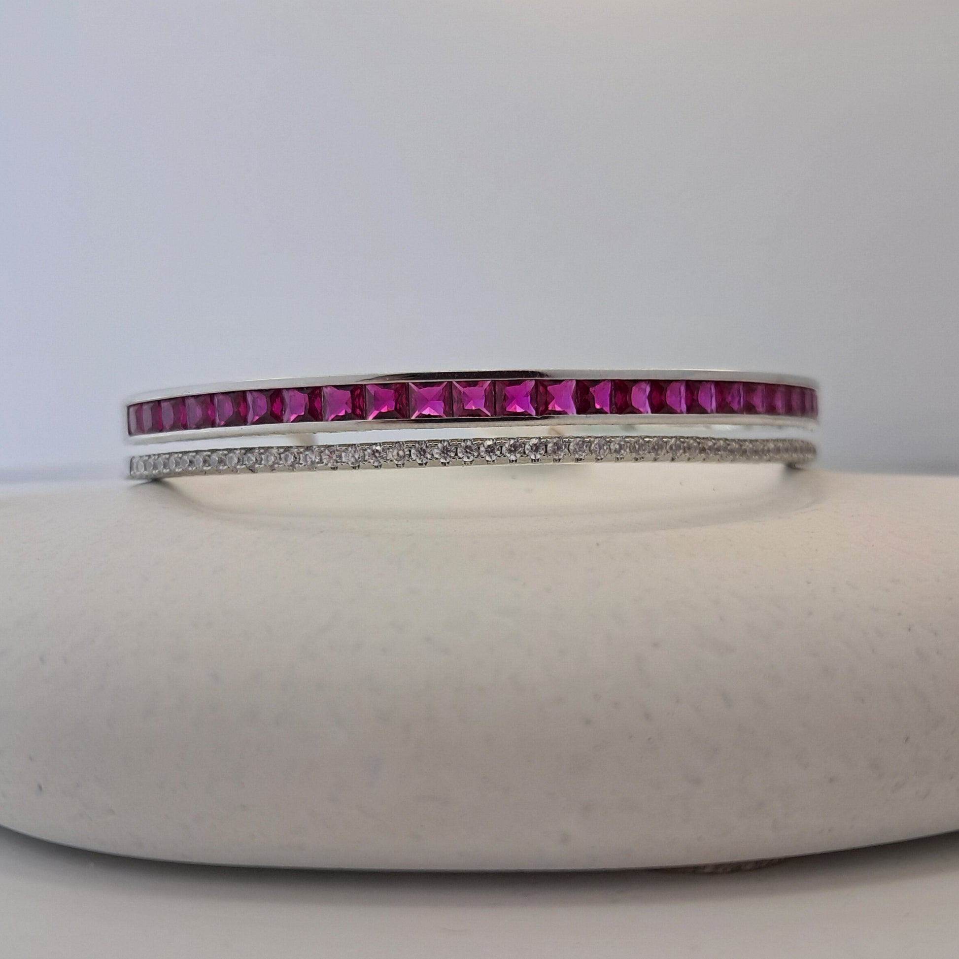 Bangle with pink gemstones on a white background