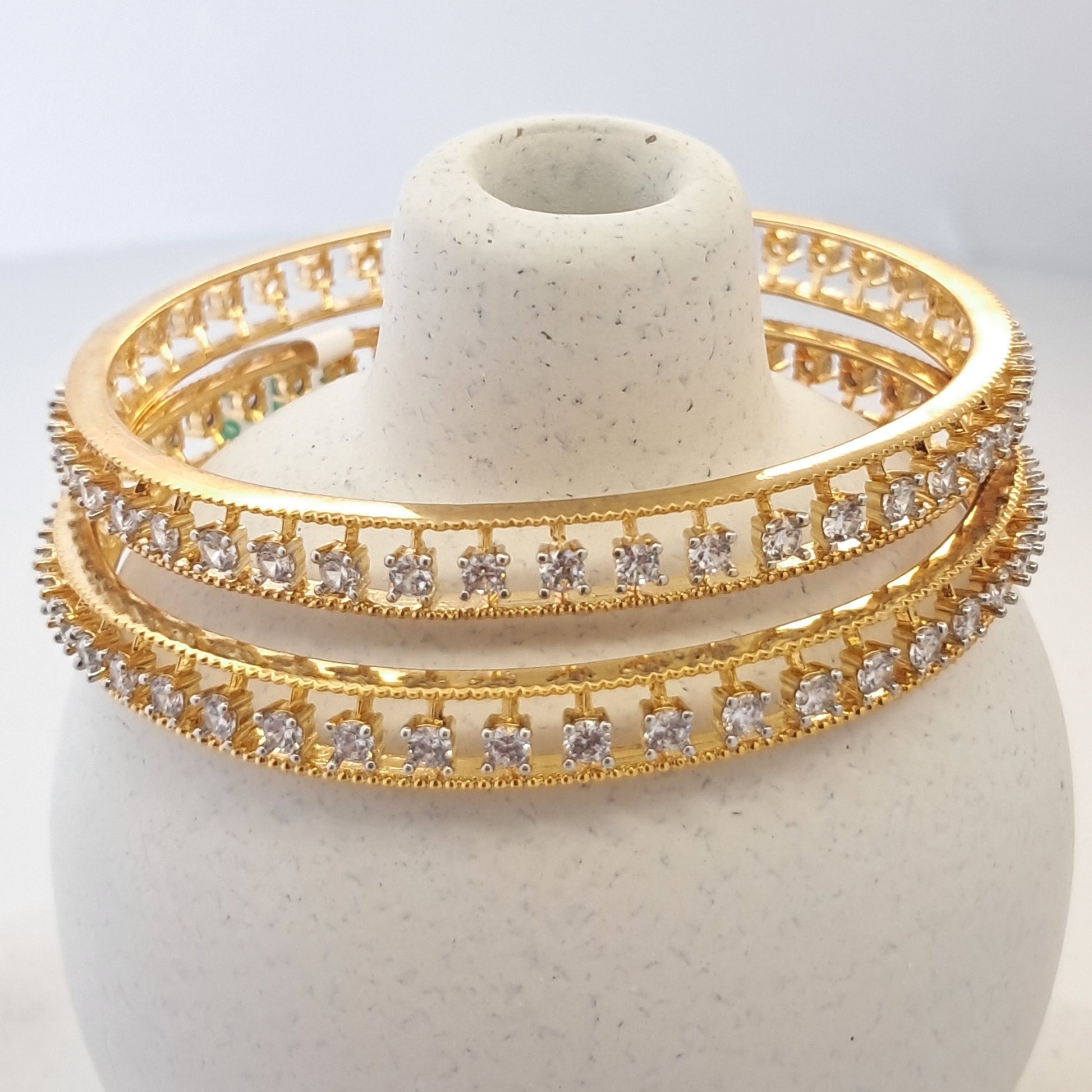 Gold bracelet with diamond accents on a white stone surface