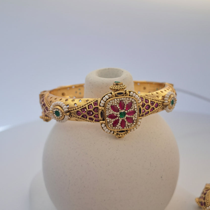 Gold bracelet with gemstones on a white background