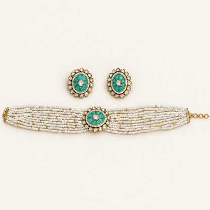 A traditional Indian jewelry set featuring a multi-strand beaded bracelet, matching earrings, and a necklace. The jewelry is decorated with white and gold beads, accented by oval turquoise inlay and small white stones.