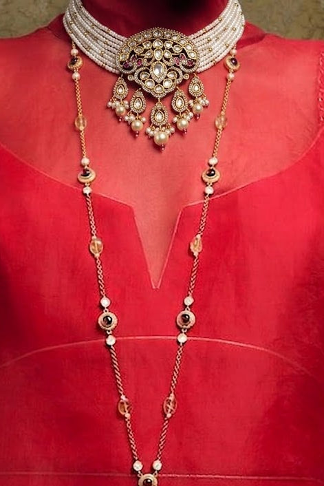 A traditional Indian gold and silver jewelry set displayed on a red dress form. The set includes a multi-strand silver choker collar, a long gold and silver beaded necklace (manglik), and a matching long silver chain with gold tassel.