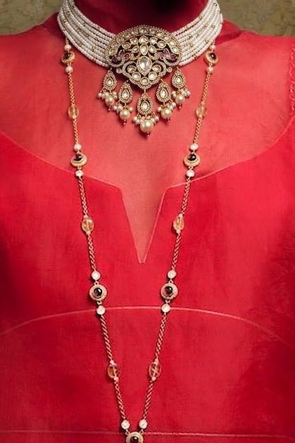 A traditional Indian gold and silver jewelry set displayed on a red dress form. The set includes a multi-strand silver choker collar, a long gold and silver beaded necklace (manglik), and a matching long silver chain with gold tassel.